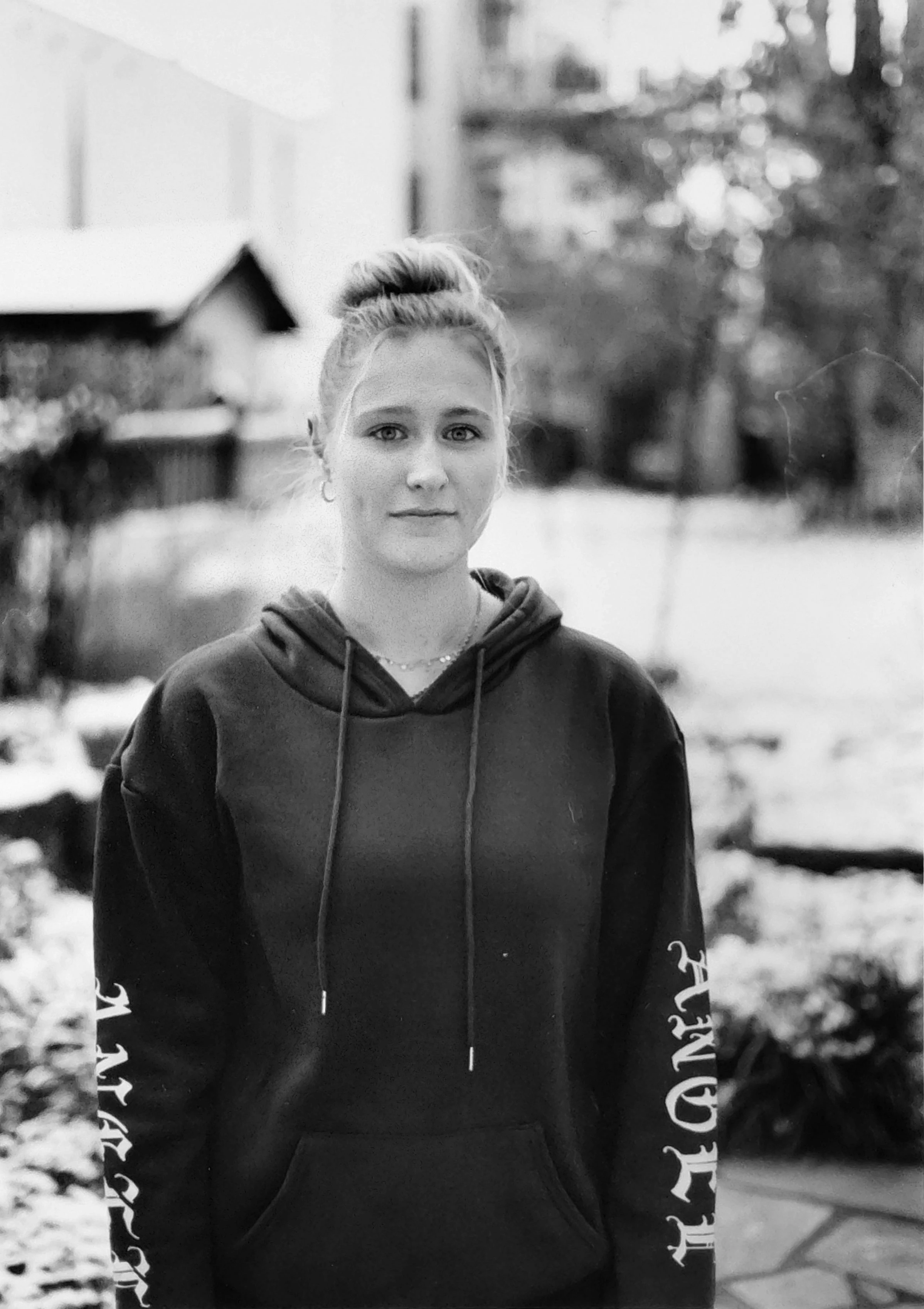 Ein analoges Foto einer jungen Frau in dunklem Hoodie