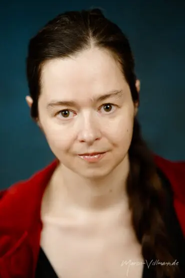 Portrait einer jungen Frau mit dunklen Haaren und roter Jacke